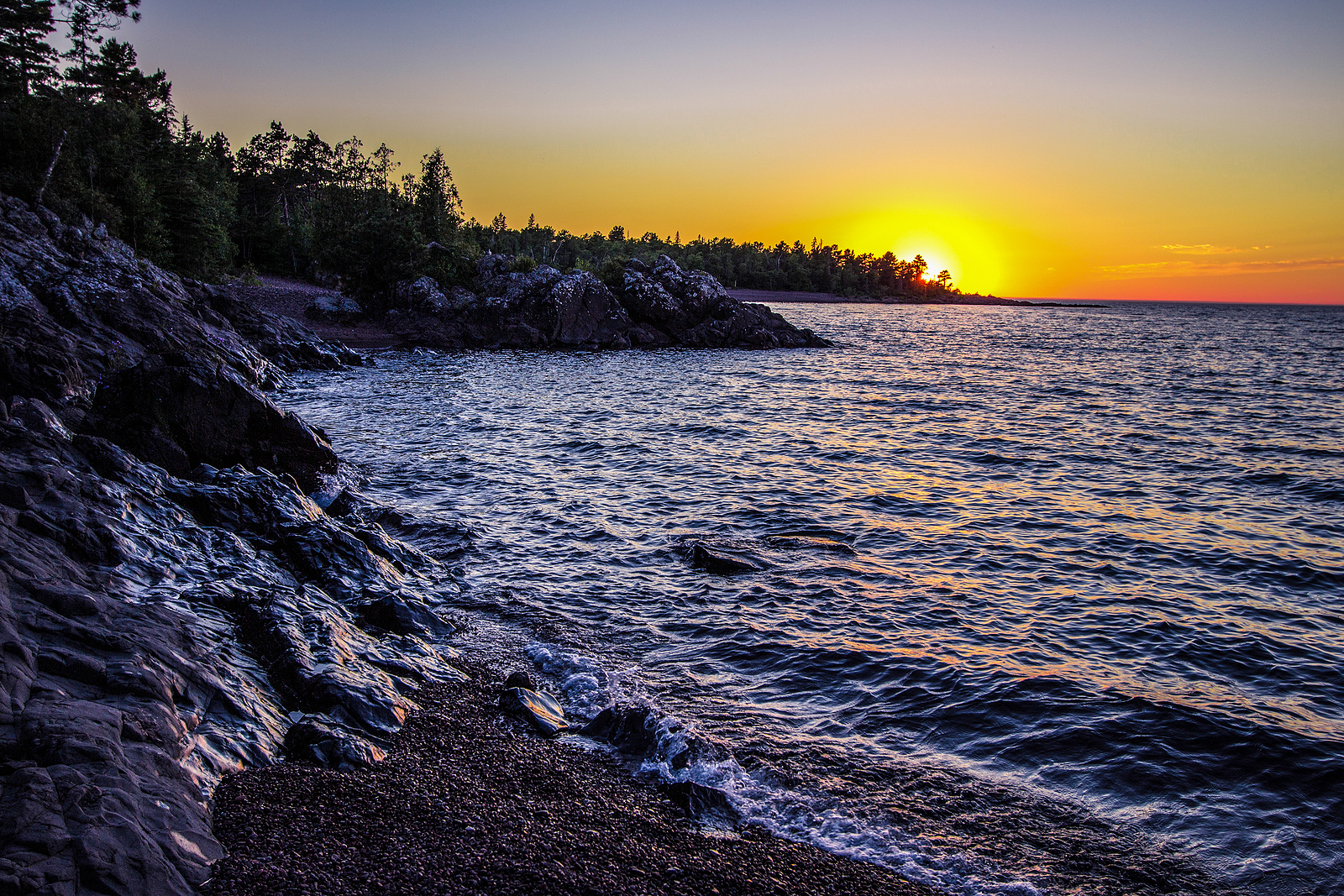 Copper Harbor Sunset. Waves crash on a remote shore of Lake Superior at the northern portion of the Keweenaw Peninsula in Copper Harbor, Michigan.