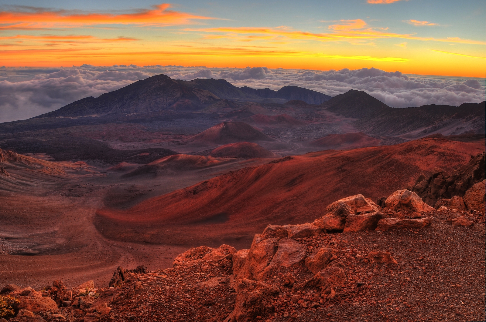 Volcanic crater landscape with beautiful orange clouds at sunrise taken at Haleakala National Park in Maui Hawaii.