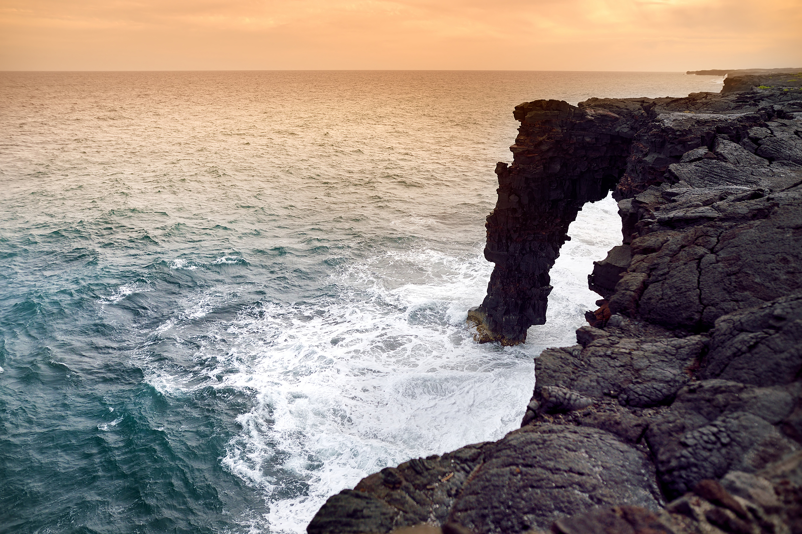 Holei Sea Arch at sunset. Natural arch is located at the end of the Chain of Craters Road in the Volcanoes National Park on the Big Island of Hawaii USA