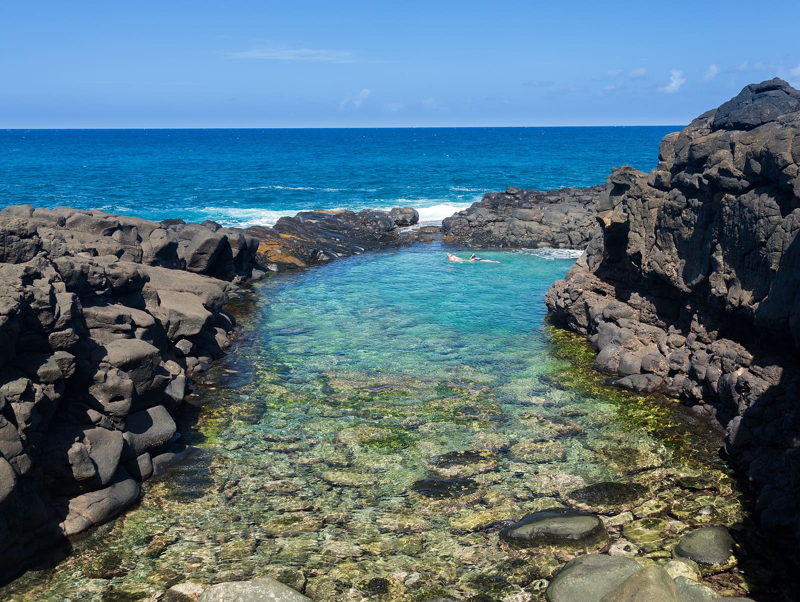 Snorkeling swimmers in Queens Bath near Princeville Kauai