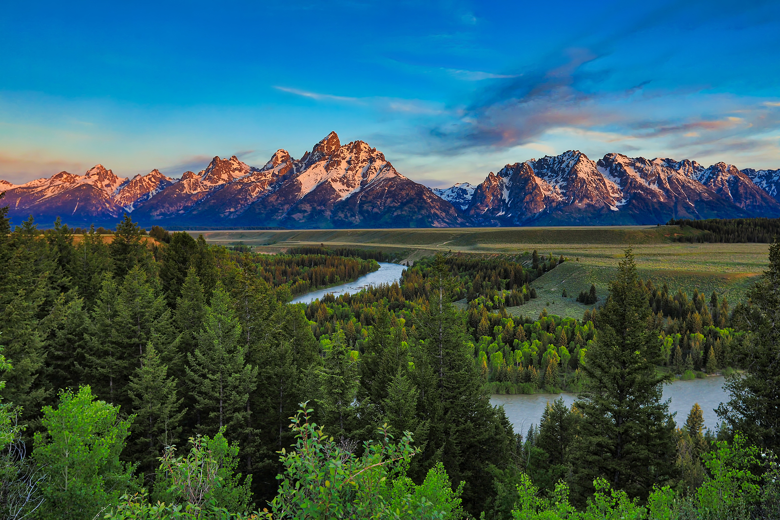 Sunrise from the Snake River Overlook in Wyoming with the Grand Tetons in the background.
