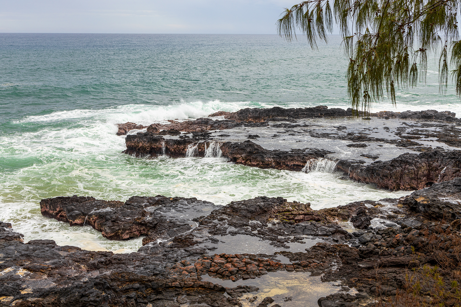 Spouting Horn Park on Kauai Island, Hawaii. Water being sprayed out of the Spouting Horn an old volcanic lava tube